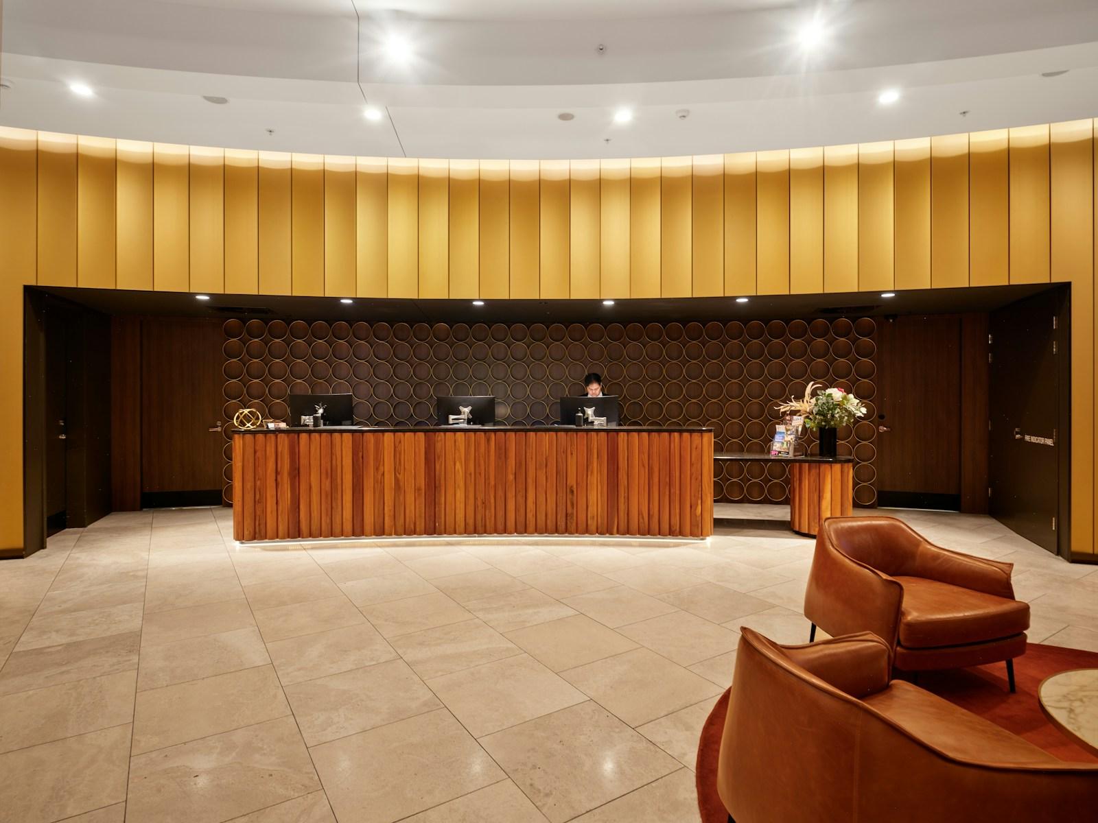 Front desk staff welcoming guests in a warm hotel lobby