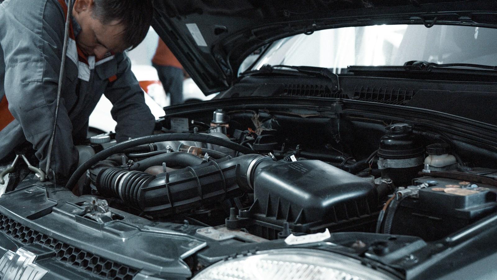 A mechanic inspecting a car engine in a workshop