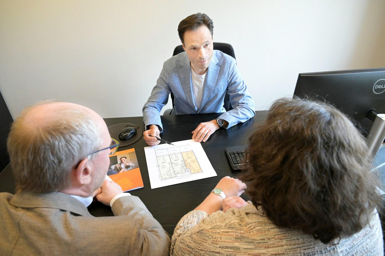 A consultant walking clients through a plan at a desk