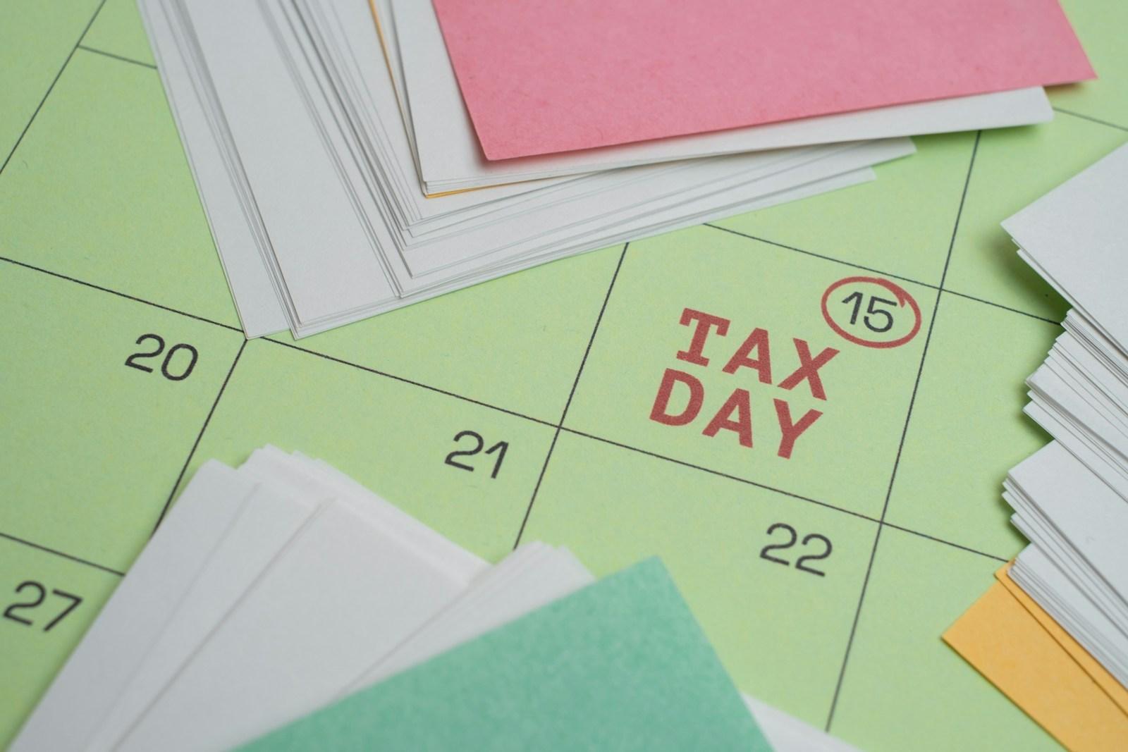 A calendar with the tax deadline marked, beside the paperwork