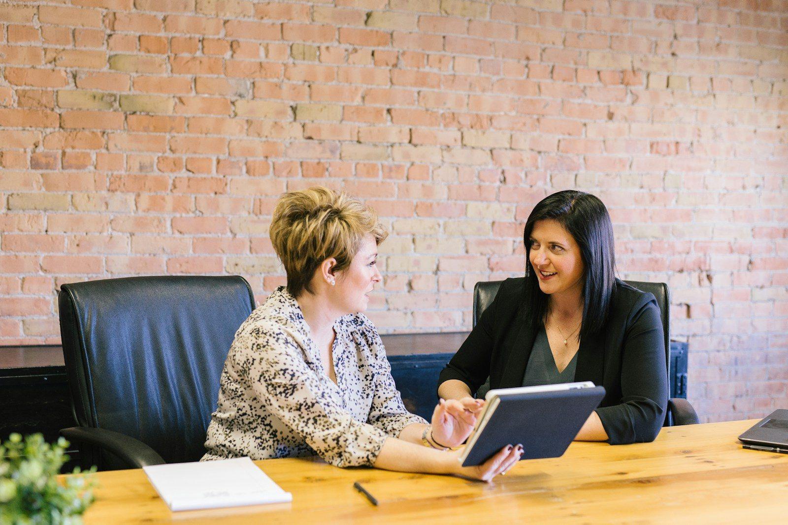 An adviser explaining documents to a client across a desk.